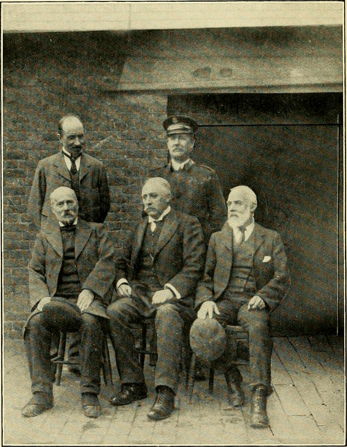 A group of formally dressed men pose outdoors, illustrating a historical aspect of internet culture.